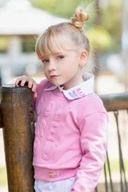 Photo 2: a young girl in a pink jumper.